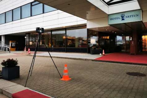Laserscanner auf dem Stativ vor dem Eingang eines Hotels