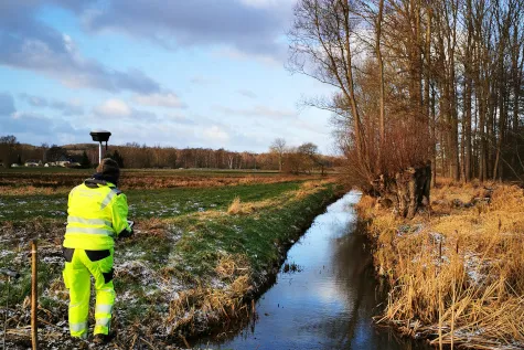 Vermesser erfasst Punkte im Gelände mit einem GNSS-Empfänger