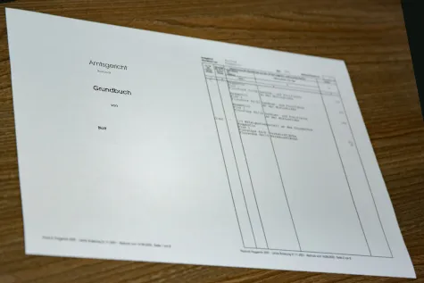 Land register extract and documents relating to a property on a table