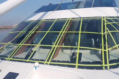 Glazing of a yacht in the harbour, the panes marked with tape for the measurement
